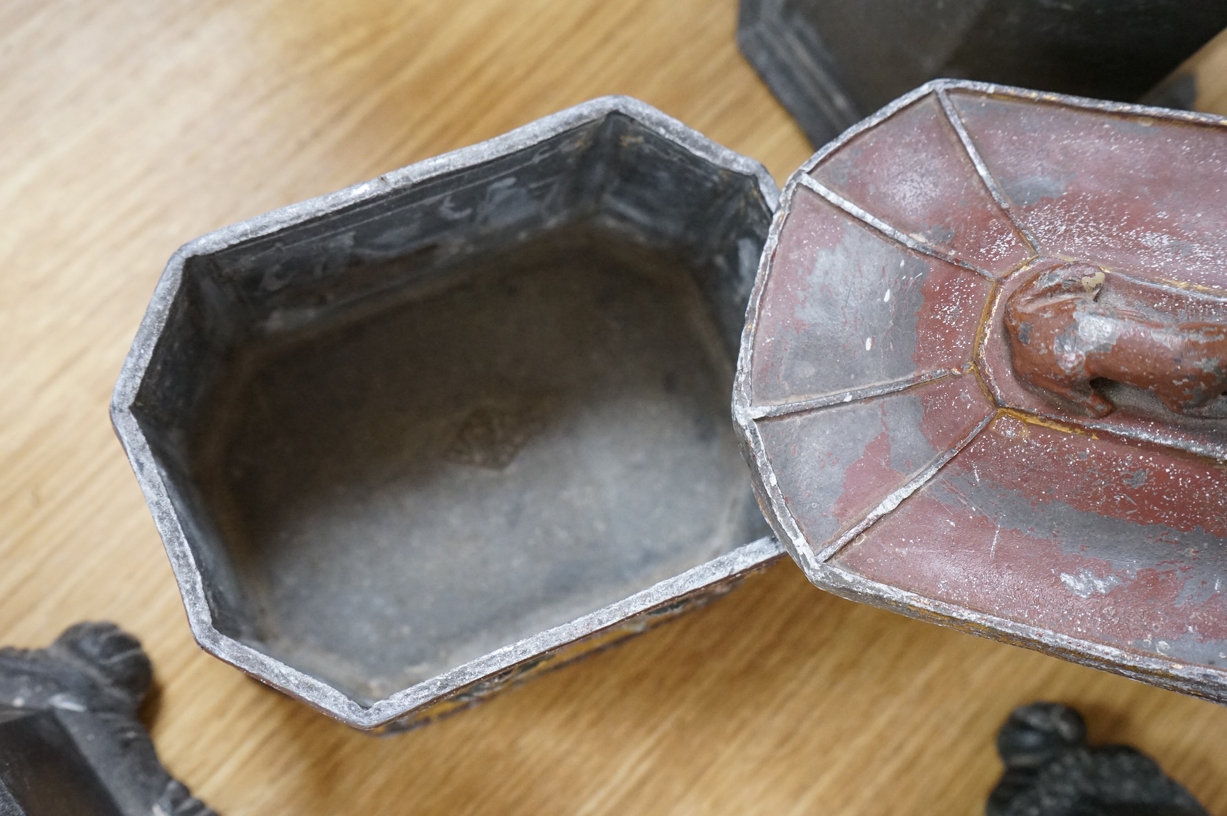 A collection of ten early 19th century lead tobacco boxes, to include an octagonal example, decorated in relief with the remains of red and gilt paint, largest 13cm wide